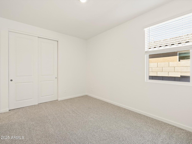 unfurnished bedroom featuring carpet floors, a closet, and baseboards