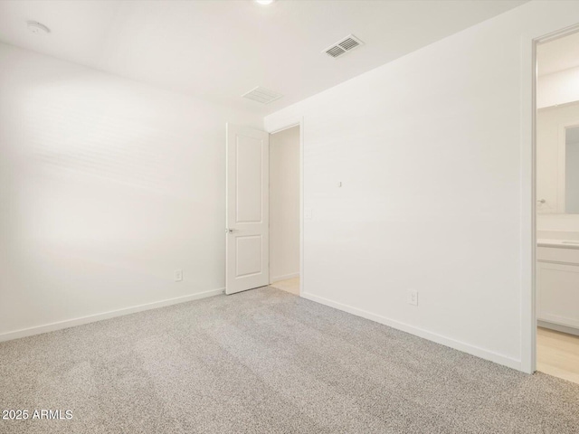 unfurnished room featuring light carpet, visible vents, and baseboards