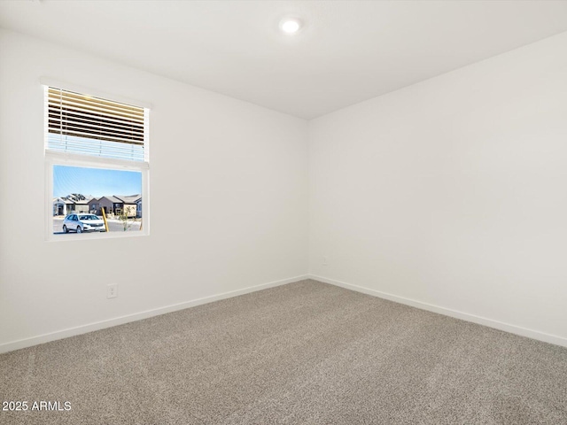 carpeted spare room featuring baseboards