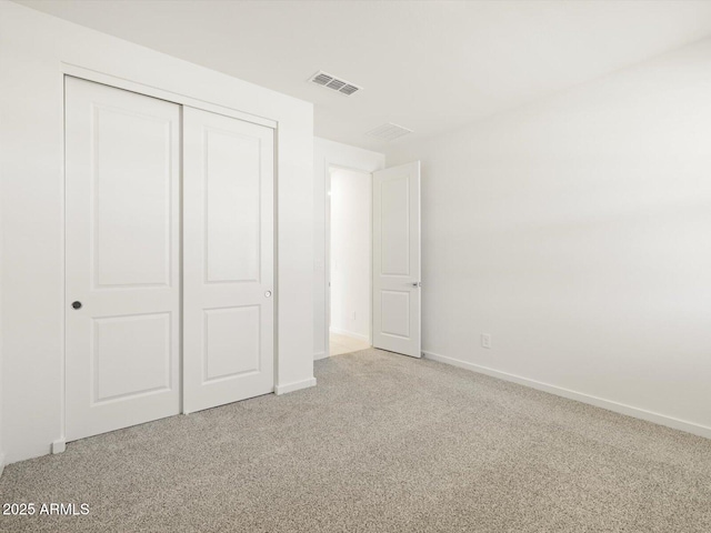 unfurnished bedroom featuring a closet, carpet flooring, visible vents, and baseboards