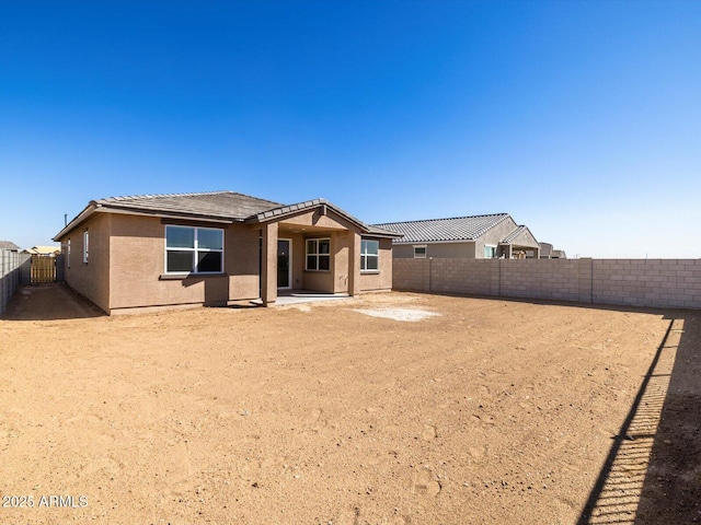 rear view of property featuring a patio area, a fenced backyard, and stucco siding