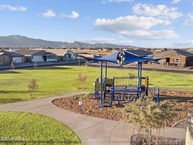 exterior space featuring a residential view, a mountain view, and a lawn