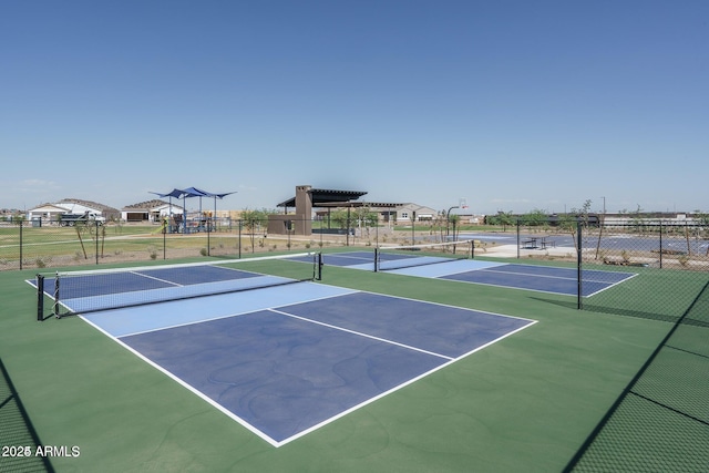 view of tennis court featuring fence