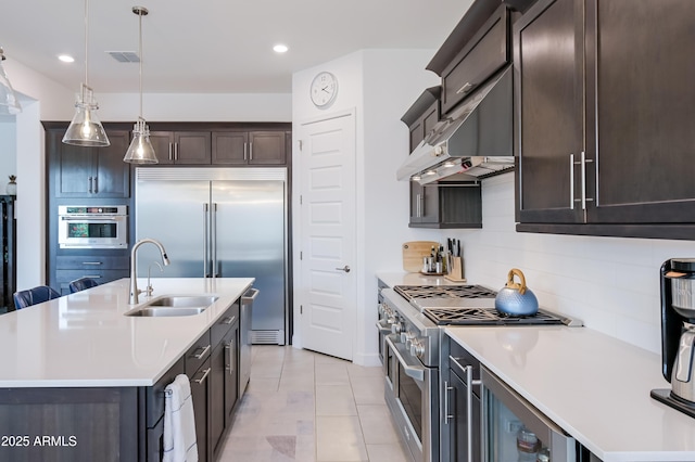 2513 E Pleasant Ln, Phoenix, AZ 85042 - kitchen featuring premium appliances, a sink, dark brown cabinets, light countertops, and tasteful backsplash