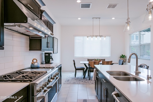2513 E Pleasant Ln, Phoenix, AZ 85042 - kitchen featuring appliances with stainless steel finishes, extractor fan, a sink, light countertops, and decorative light fixtures