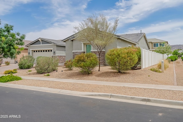 2513 E Pleasant Ln, Phoenix, AZ 85042 - view of front of home with stucco siding, an attached garage, fence, and stone siding