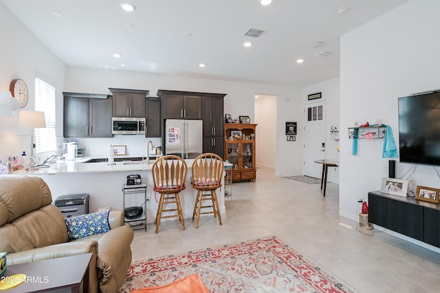 2513 E Pleasant Ln, Phoenix, AZ 85042 - kitchen with appliances with stainless steel finishes, a breakfast bar, open floor plan, a peninsula, and dark brown cabinetry