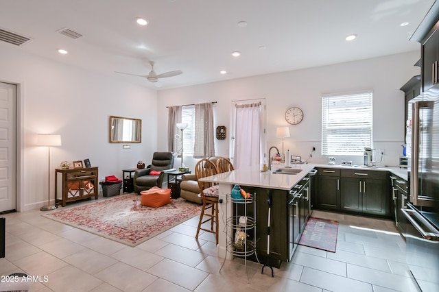 2513 E Pleasant Ln, Phoenix, AZ 85042 - kitchen with a sink, a peninsula, healthy amount of natural light, light countertops, and recessed lighting