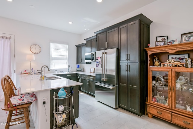 2513 E Pleasant Ln, Phoenix, AZ 85042 - kitchen with stainless steel appliances, a sink, a peninsula, a kitchen bar, and light countertops
