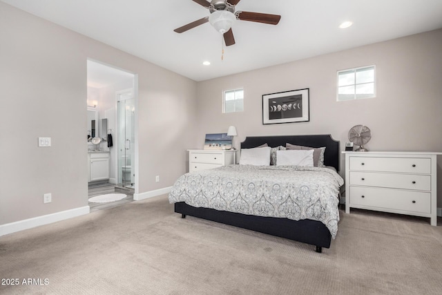 carpeted bedroom with ceiling fan, multiple windows, and ensuite bathroom