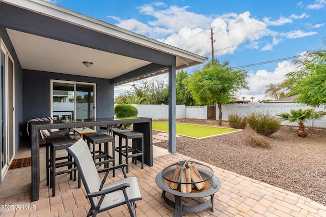 view of patio / terrace featuring an outdoor fire pit and a bar