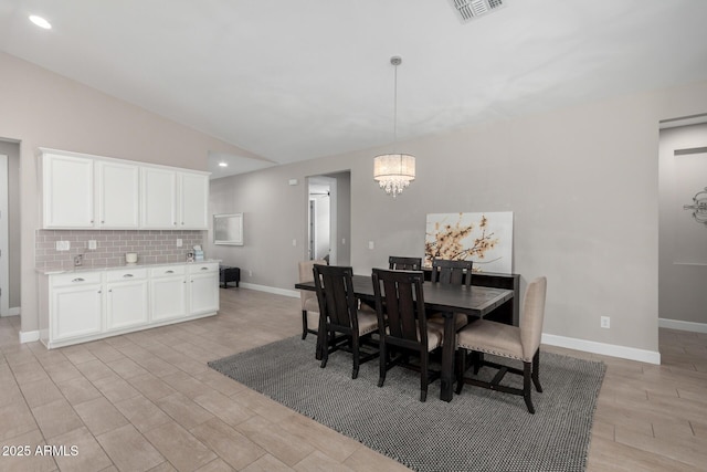 dining area with vaulted ceiling and a chandelier