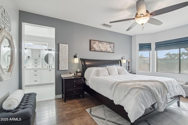 bedroom featuring ensuite bath, wood finished floors, visible vents, and ceiling fan