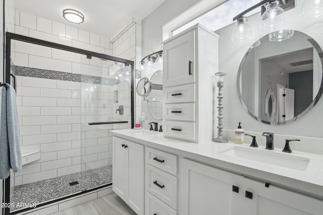 full bath with double vanity, a shower stall, and a sink