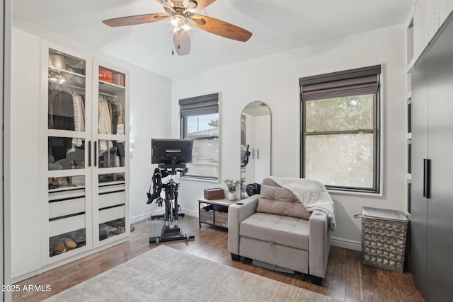 sitting room with baseboards, a ceiling fan, and wood finished floors