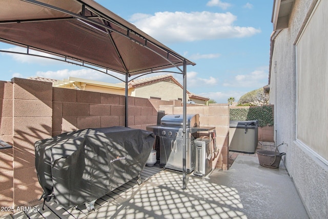 view of patio with a gazebo, a grill, and fence