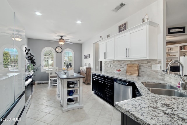 kitchen featuring a ceiling fan, visible vents, a sink, dishwasher, and backsplash