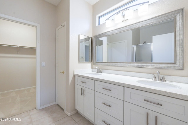 bathroom with tile patterned flooring, a shower with shower door, and vanity