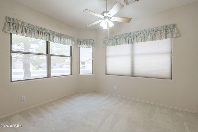 carpeted empty room featuring a wealth of natural light and ceiling fan