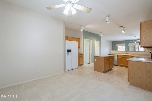 kitchen featuring a center island, stainless steel dishwasher, sink, white fridge with ice dispenser, and ceiling fan