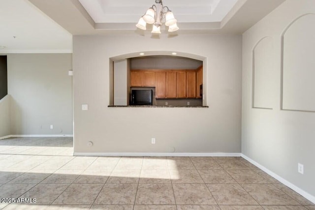 3820 E Mcdowell Rd Unit 102, Phoenix, AZ 85008 - empty room featuring a chandelier, a raised ceiling, arched walkways, and light tile patterned floors