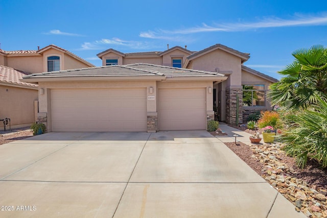 view of property with stone siding, stucco siding, concrete driveway, and an attached garage