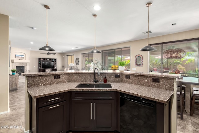 kitchen featuring a sink, visible vents, stone countertops, open floor plan, and dishwasher