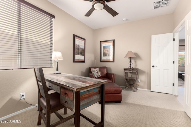 carpeted office space featuring baseboards, visible vents, and ceiling fan