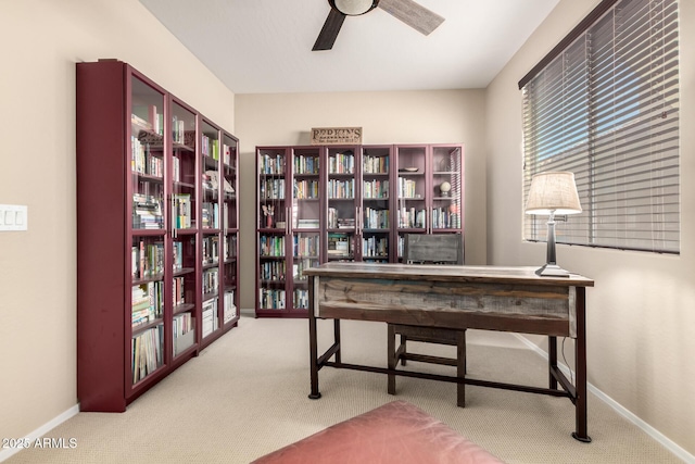 home office featuring carpet, ceiling fan, and baseboards