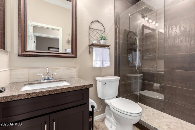 bathroom with tiled shower, toilet, and vanity
