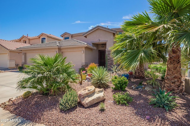 view of front facade with a tile roof, stucco siding, driveway, and an attached garage