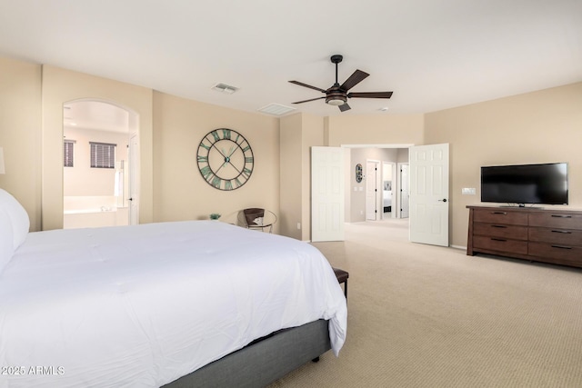 bedroom with visible vents, a ceiling fan, light carpet, and arched walkways