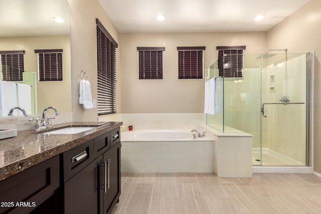 bathroom with a garden tub, a shower stall, and vanity