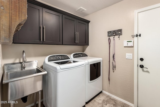 clothes washing area featuring a sink, visible vents, baseboards, separate washer and dryer, and cabinet space