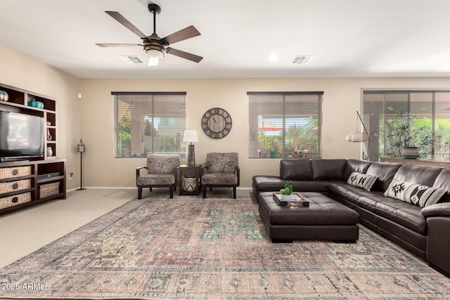 carpeted living area featuring visible vents, a ceiling fan, and baseboards
