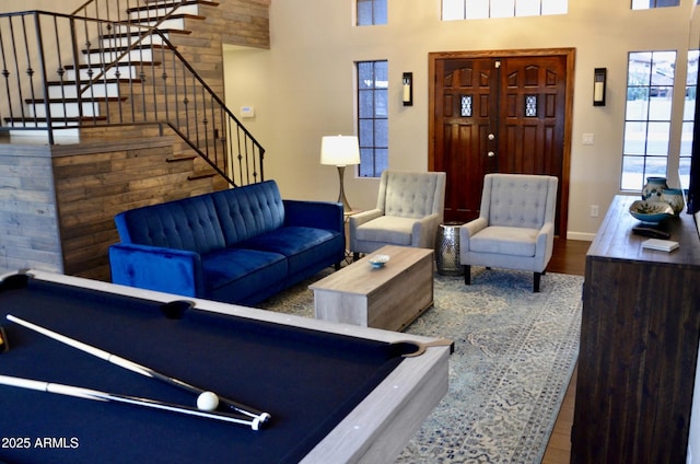 living room with baseboards, stairs, a towering ceiling, wood finished floors, and billiards