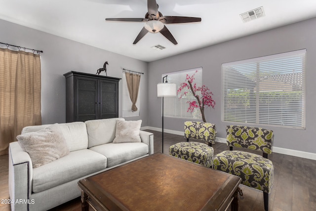 living room featuring dark wood-type flooring and ceiling fan