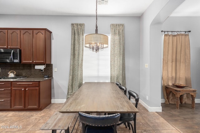 tiled dining room featuring an inviting chandelier