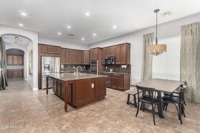 kitchen featuring tasteful backsplash, decorative light fixtures, light stone counters, and stainless steel appliances