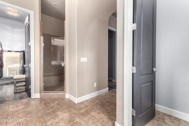 bathroom featuring a shower with door and tile patterned floors