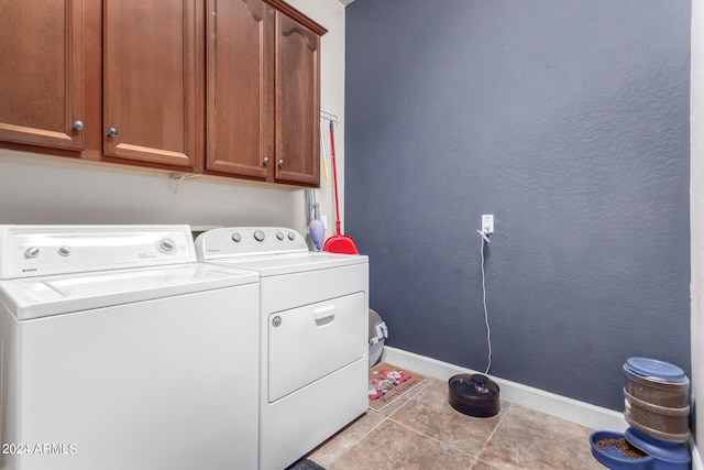 clothes washing area featuring cabinets, light tile patterned flooring, and separate washer and dryer