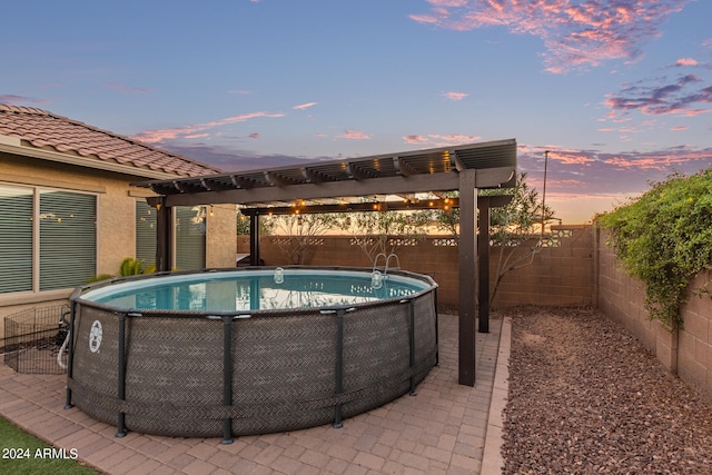 pool at dusk featuring a pergola