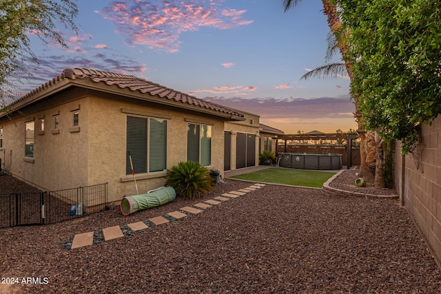 back house at dusk featuring a patio area