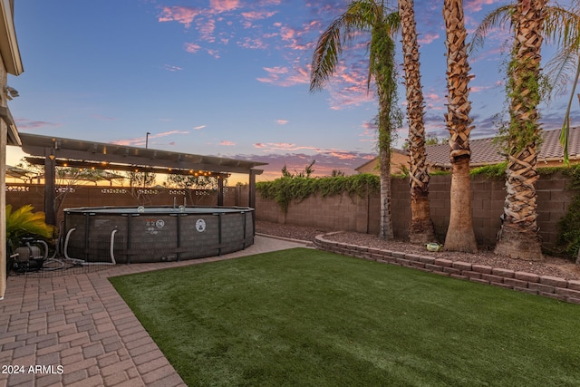 yard at dusk featuring a fenced in pool