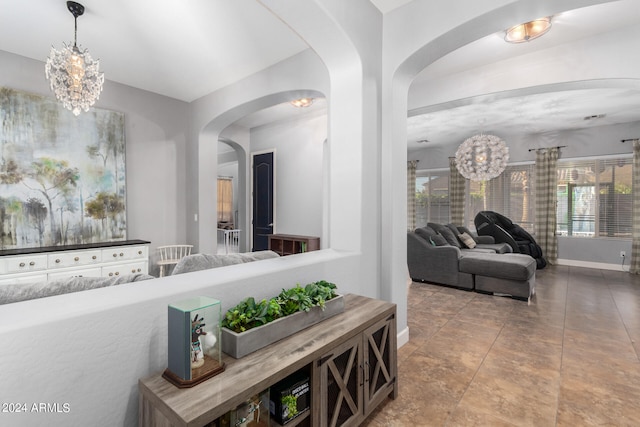 corridor with an inviting chandelier and tile patterned flooring