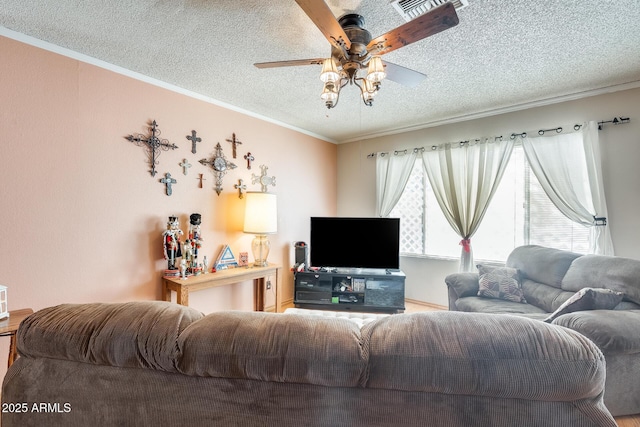 living room featuring a textured ceiling, ceiling fan, visible vents, and crown molding