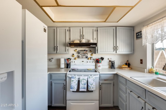 kitchen featuring under cabinet range hood, electric range, gray cabinets, and light countertops