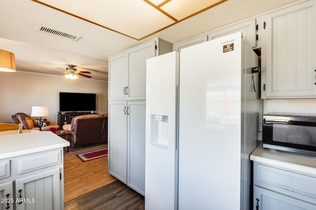 kitchen featuring ceiling fan, dark wood-style flooring, visible vents, open floor plan, and white fridge with ice dispenser