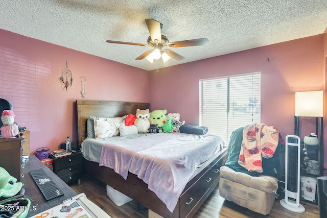 bedroom with a textured ceiling, wood finished floors, and a ceiling fan