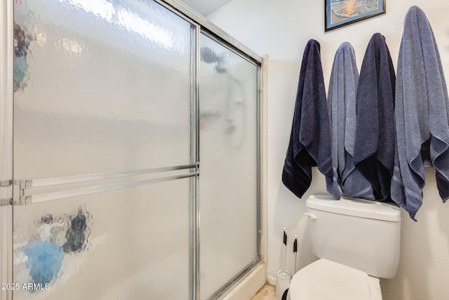 bathroom with a shower stall and toilet